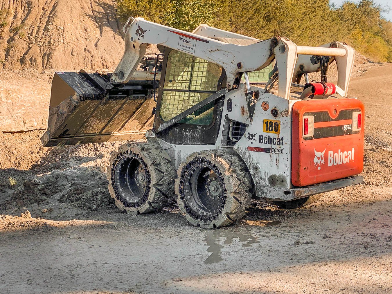This image shows a BOBCAT S570 with our traction skid steer tires the EWRS-HS