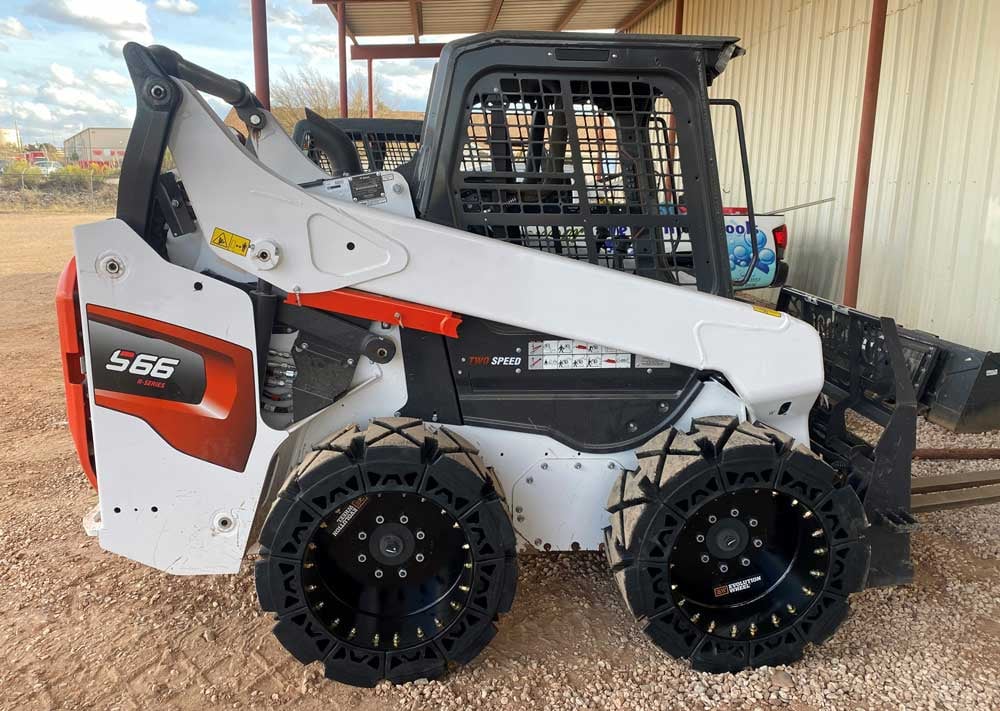 This image is shows our hard surface solid skid steer tires on a Bobcat S66.
