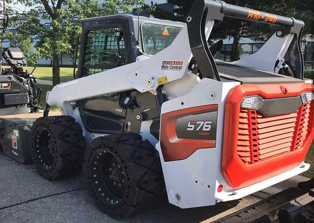 This images shows our hard surface solid skid steer tires on a Bobcat S76 skid steer.