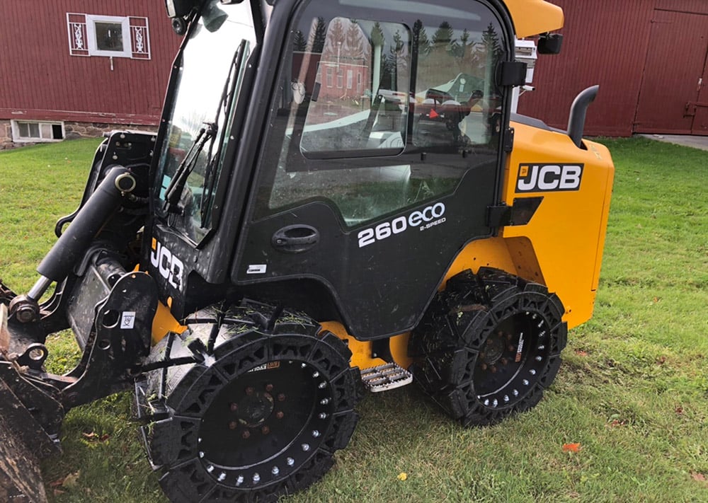 This image shows a JCB skid steer using our hard surface solid skid steer tires. 