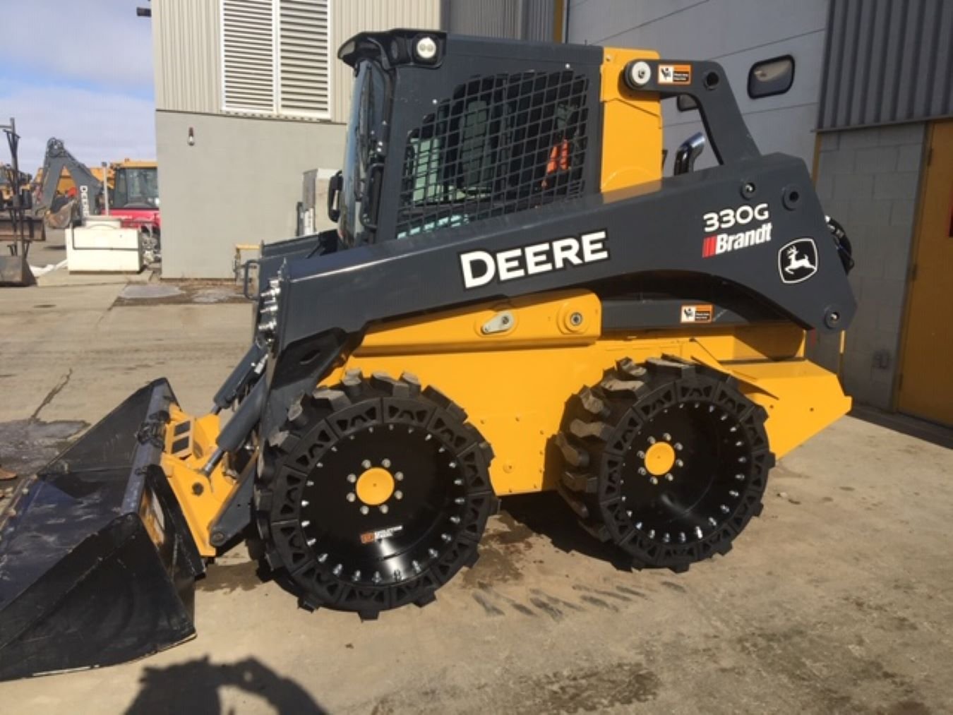 This image shows a Deere 330G skid steer using our Bobcat all terrain skid steer tires