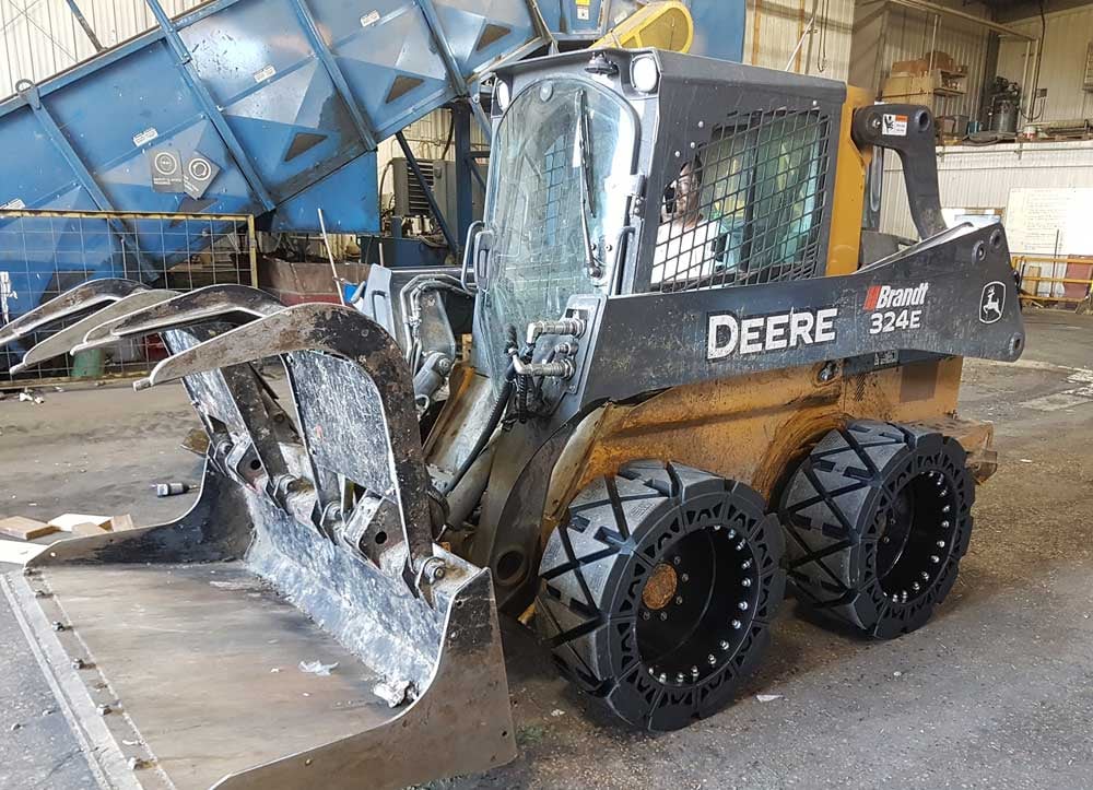 This image shows our hard surface solid skid steer tires in a waste transfer station.