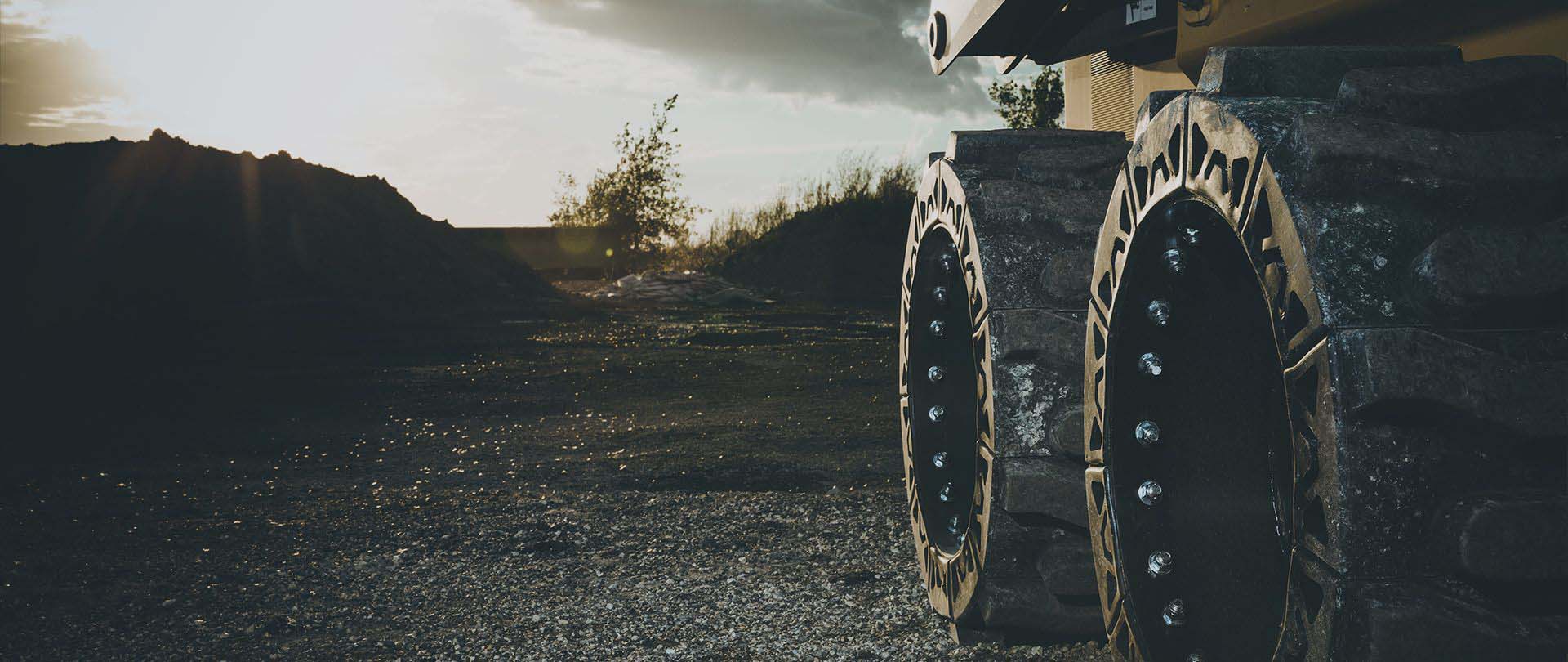 This images shows the EWRS-AT solid skid steer tire on a jobsite.